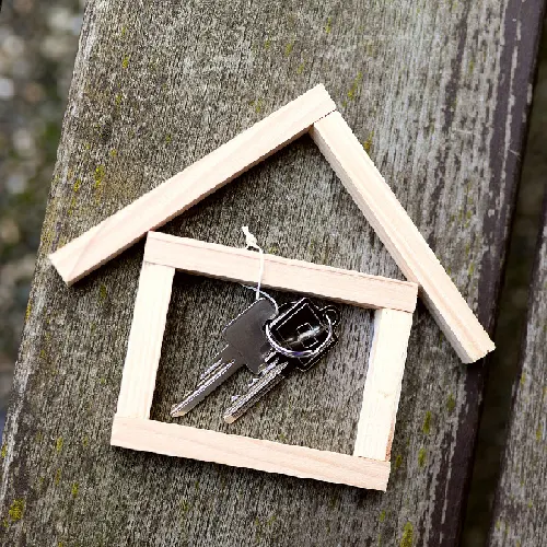 Schlüssel in einem Holzrahmen in Hausform