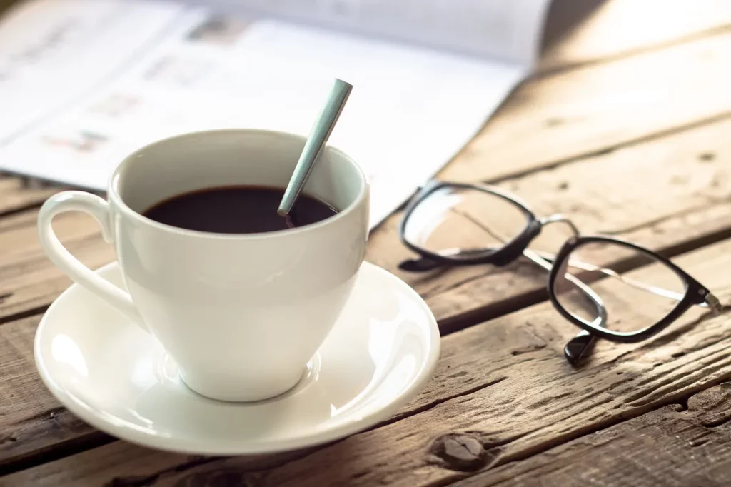 Kaffeetasse mit Brille und Zeitschrift
